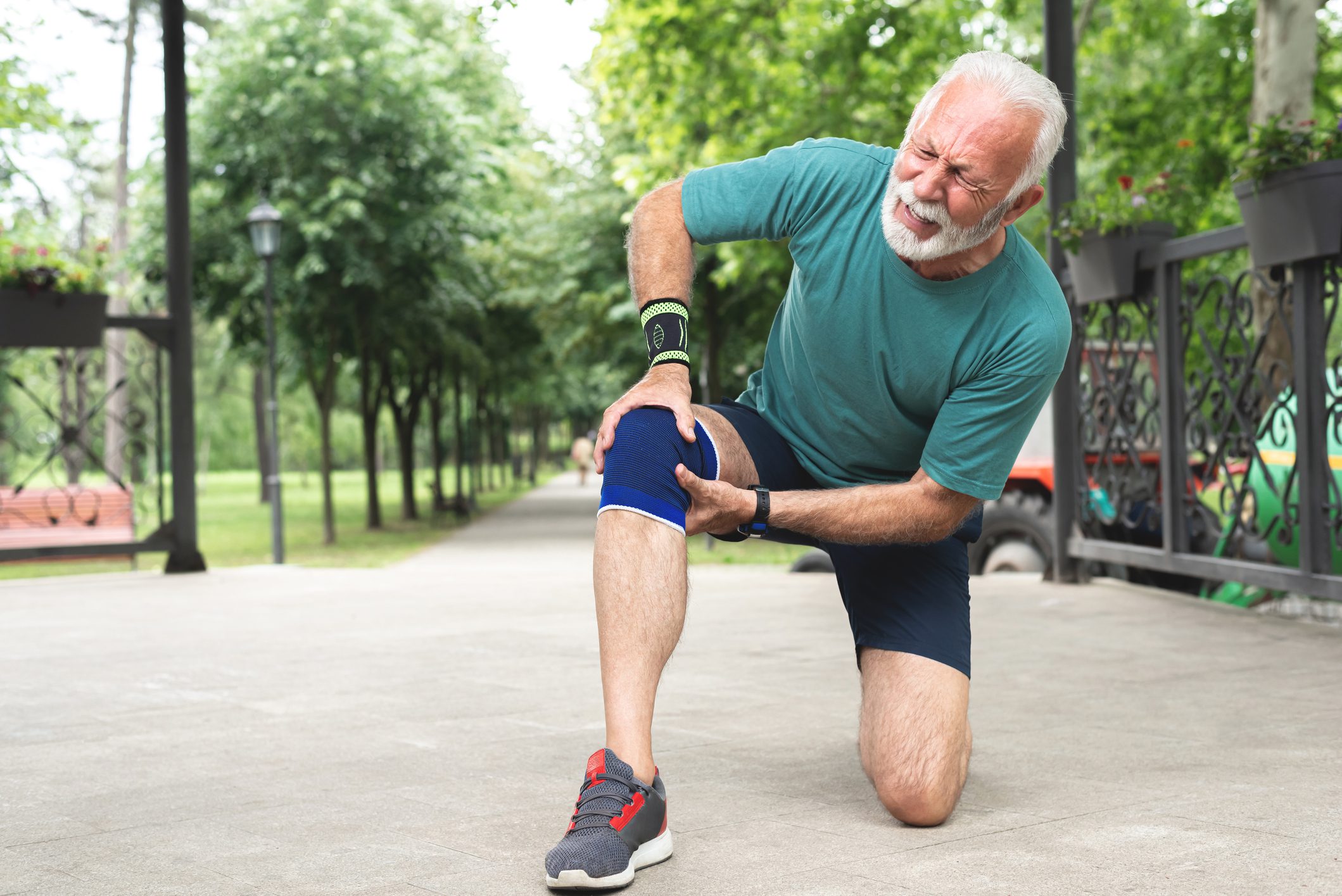 Senior man suffering with knee pain during workout Senior man suffering with knee pain during workout